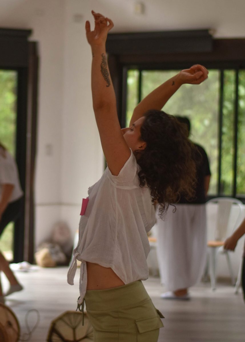 Una mujer bailando con los brazos al aire